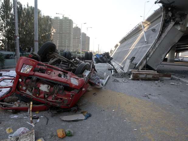  Quatro caminhões ficaram destruídos e ao menos três pessoas morreram após a queda de uma ponte. Foto: AP