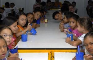 Crianças na mesa comem merenda