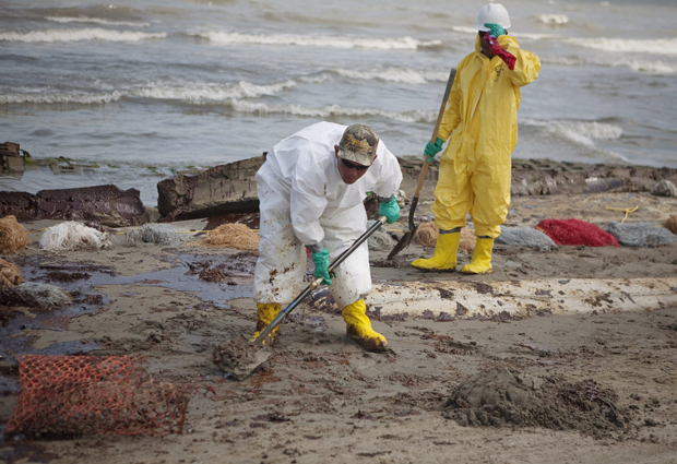 Trabalhadores contratados pela British Petroleum limpam praia no litoral da Louisiana, nos EUA.